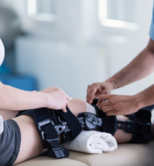 Thérapeute en train de mettre une orthèse à un patient