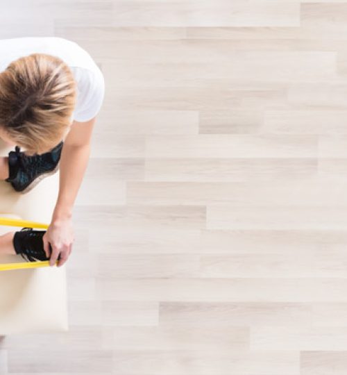 Elevated View Of A Female Physiotherapist Giving Exercise Treatment To Man